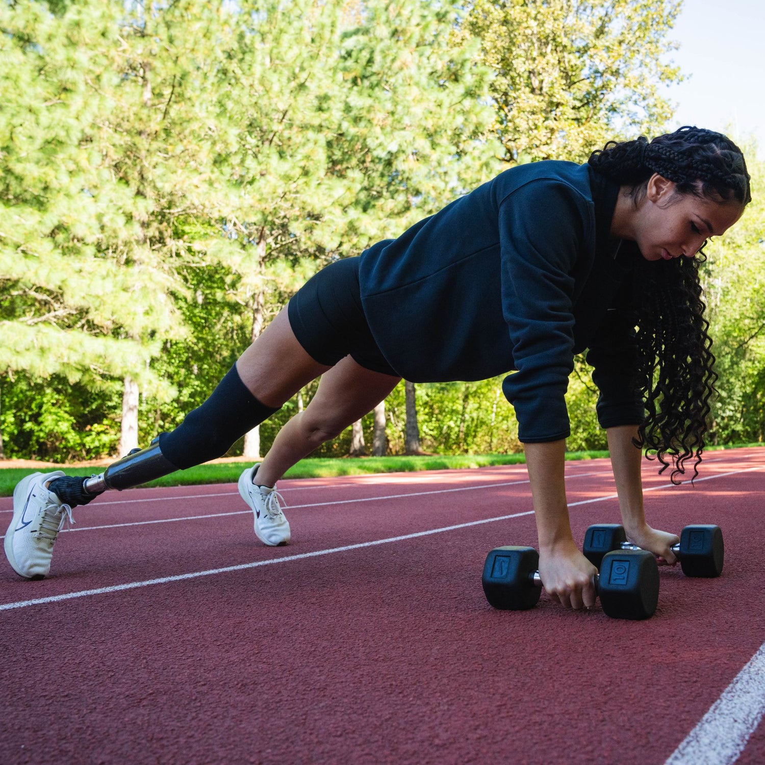 Paralympic adaptive athlete Beatriz Hatz in a plank position holding Nike Dumbbells
