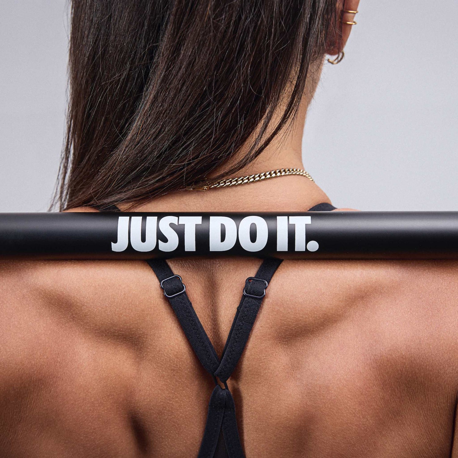Nike coated premium barbell 15kg Just Do It logo featured clearly on female athlete's back