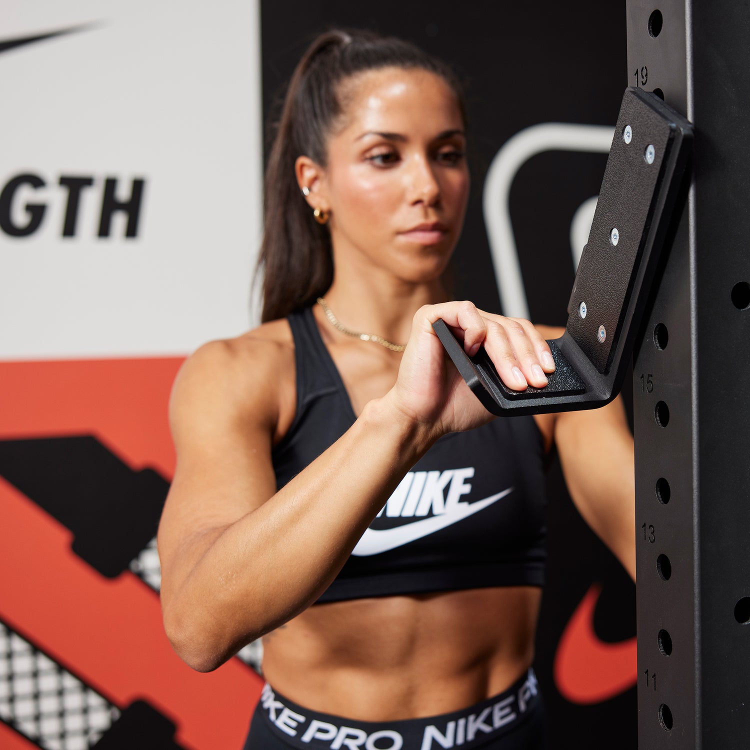 Athlete attaching the J-cup to the Nike Squat Rack
