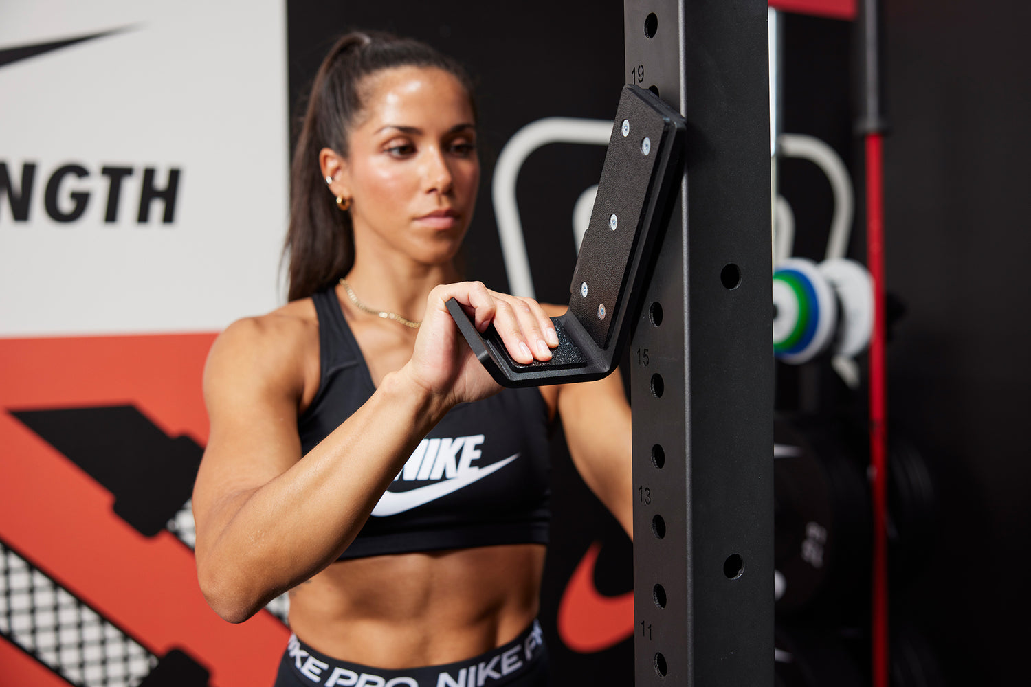 Athlete attaching J-Cups to the Nike Squat Stand