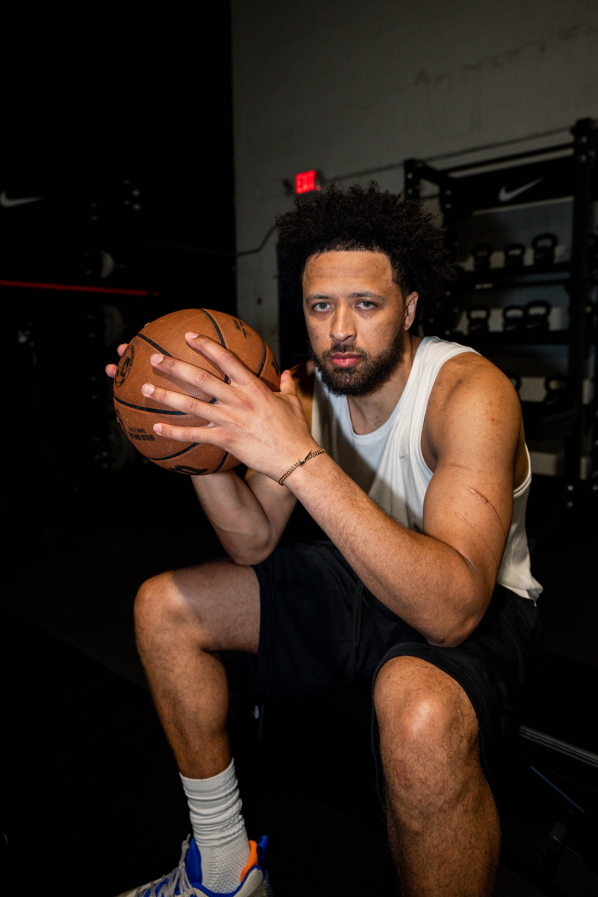 Cade Cunningham seated in the gym, holding a basketball