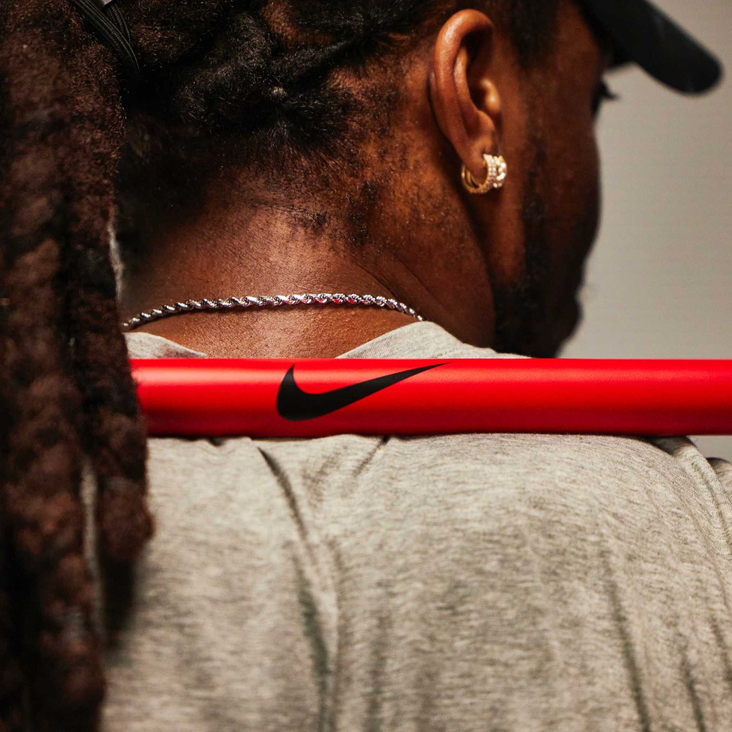 Red Swoosh Nike Coated Premium Barbell 20kg resting on Nike Athlete Derrick Henry's back before a lift