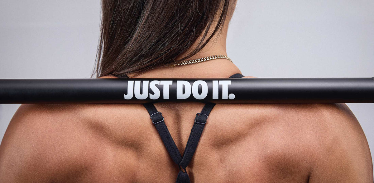 Nike coated premium barbell 15kg Just Do It logo featured clearly on female athlete's back
