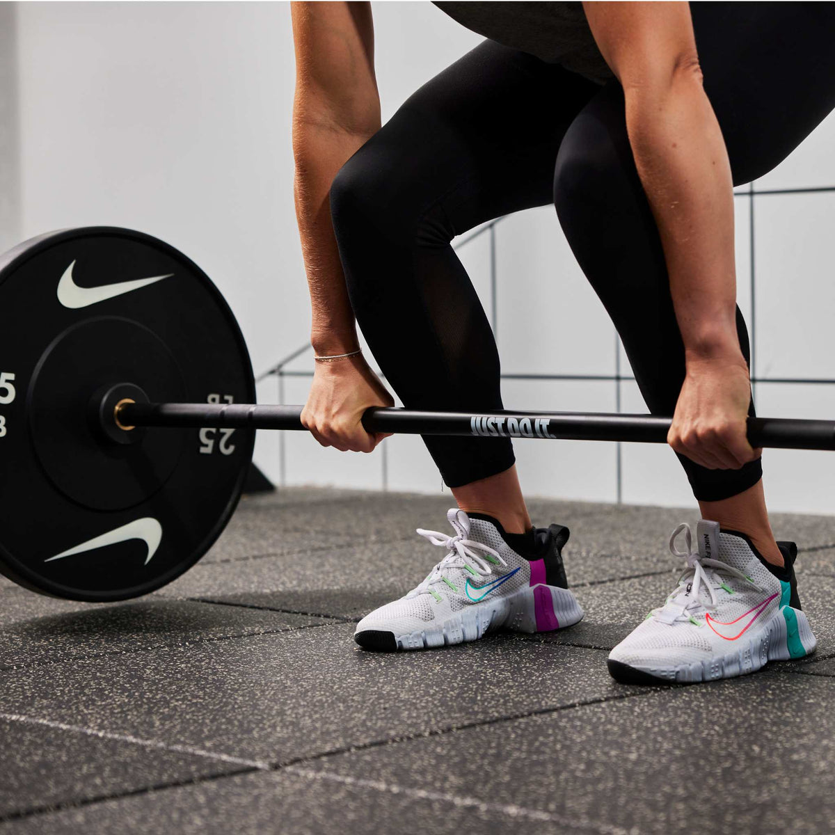 Athlete lifting the Nike coated Premium Barbell 15kg with Nike Rubber Bumper Plates 25 LB