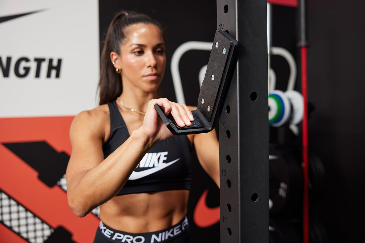 Athlete attaching the J-cup to the Nike Squat Rack